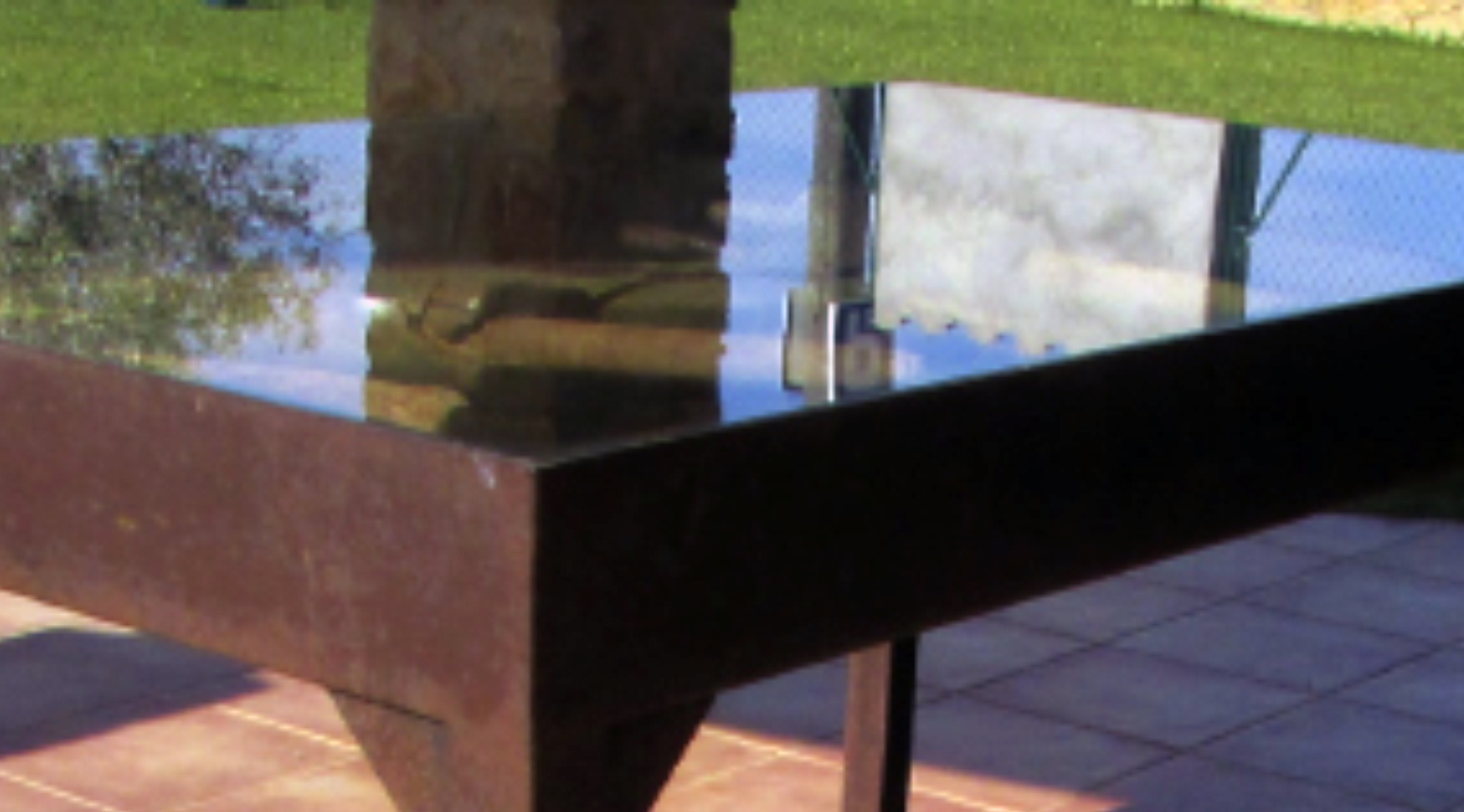 Mesa de exterior elegante en estructura de forja con superficie de vidrio